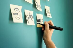 付箋に書き込む手。キャリア設計のために無意識の判断基準を言語化するセルフコーチングのイメージ図