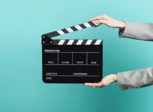 クラップボードを持つ手。コーチングを通じたキャリア設計で人生が動き出す様子を象徴する画像